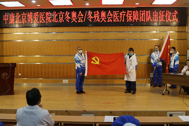 图为中康副主任密忠祥向医疗保障队授予党旗